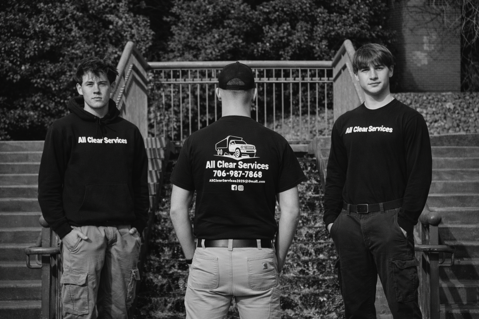 Moving company team in black shirts standing together on outdoor steps