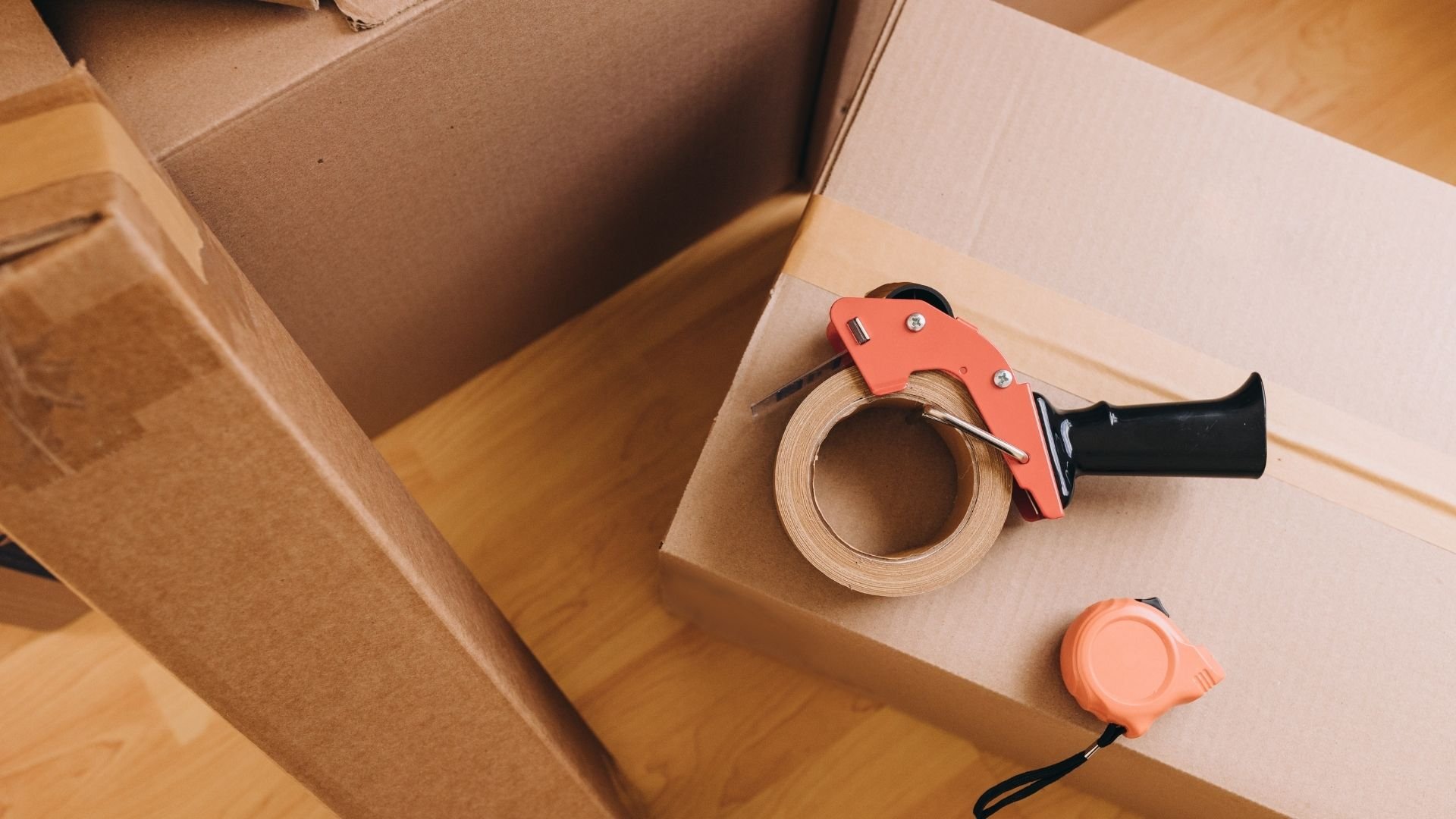 Moving boxes with packing tape dispenser and tape for relocation