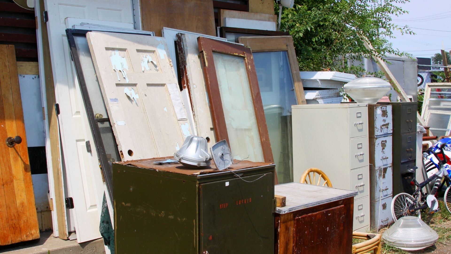 Moving day clutter with doors, file cabinets, and old furniture outside